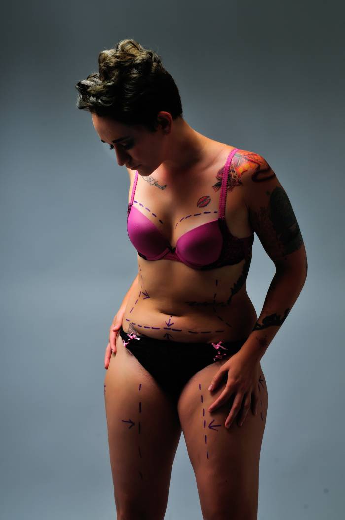 femme en lingerie observe ses imperfections physiques