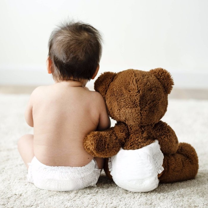 bébé en couche avec nounours